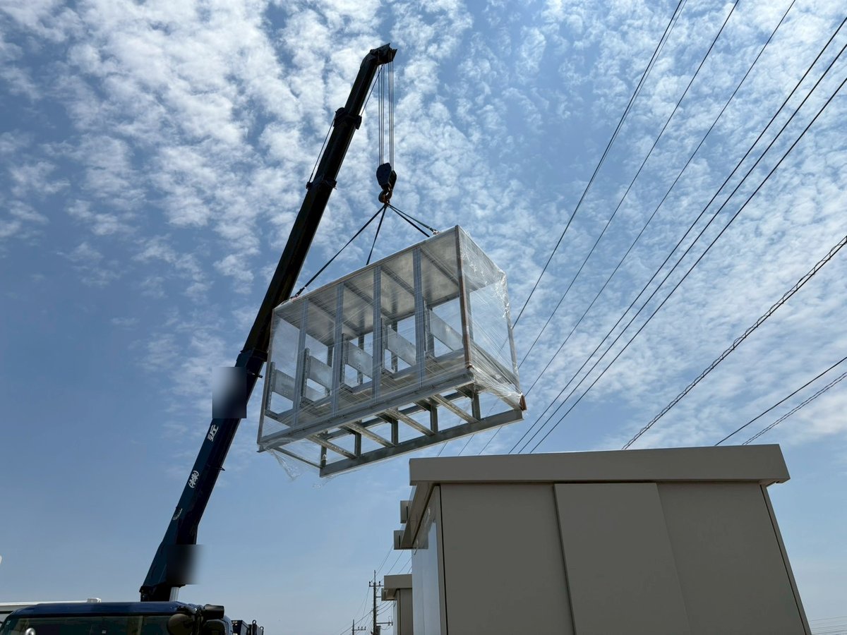 機器を載せる架台をクレーンで吊り上げる様子