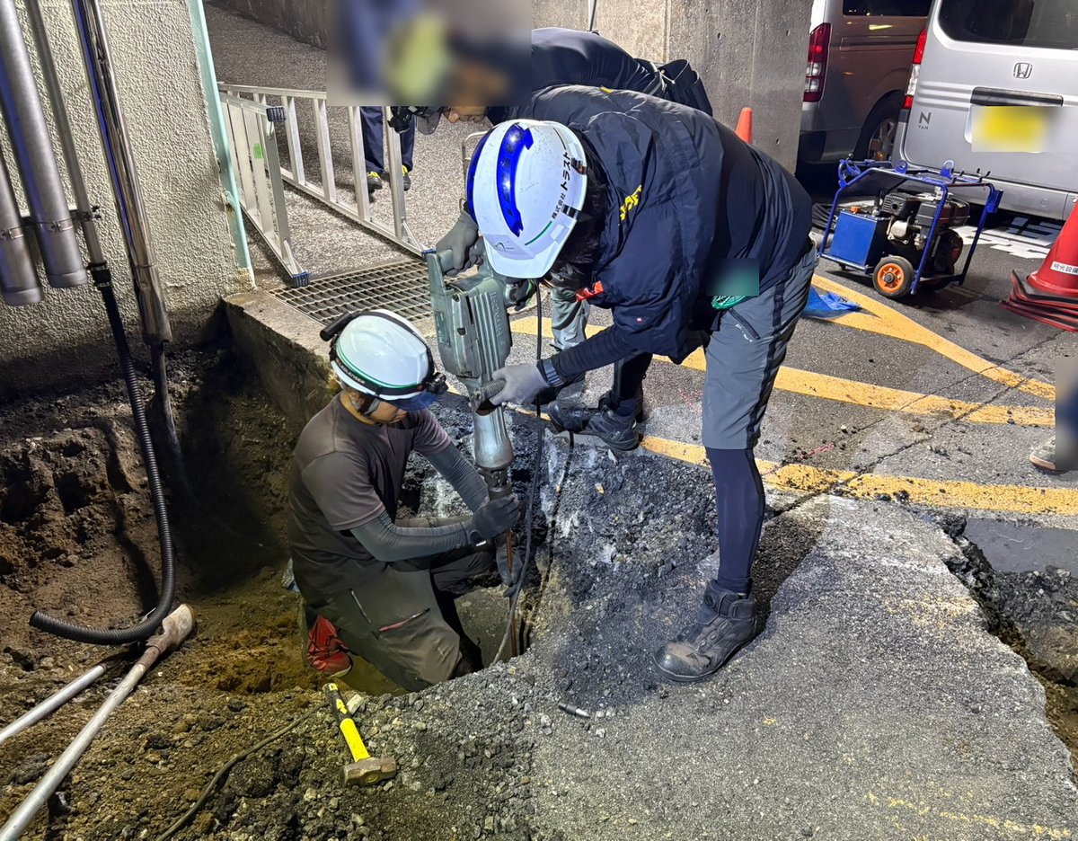 夜間にアスファルトを斫って接地極を打ち込む作業
